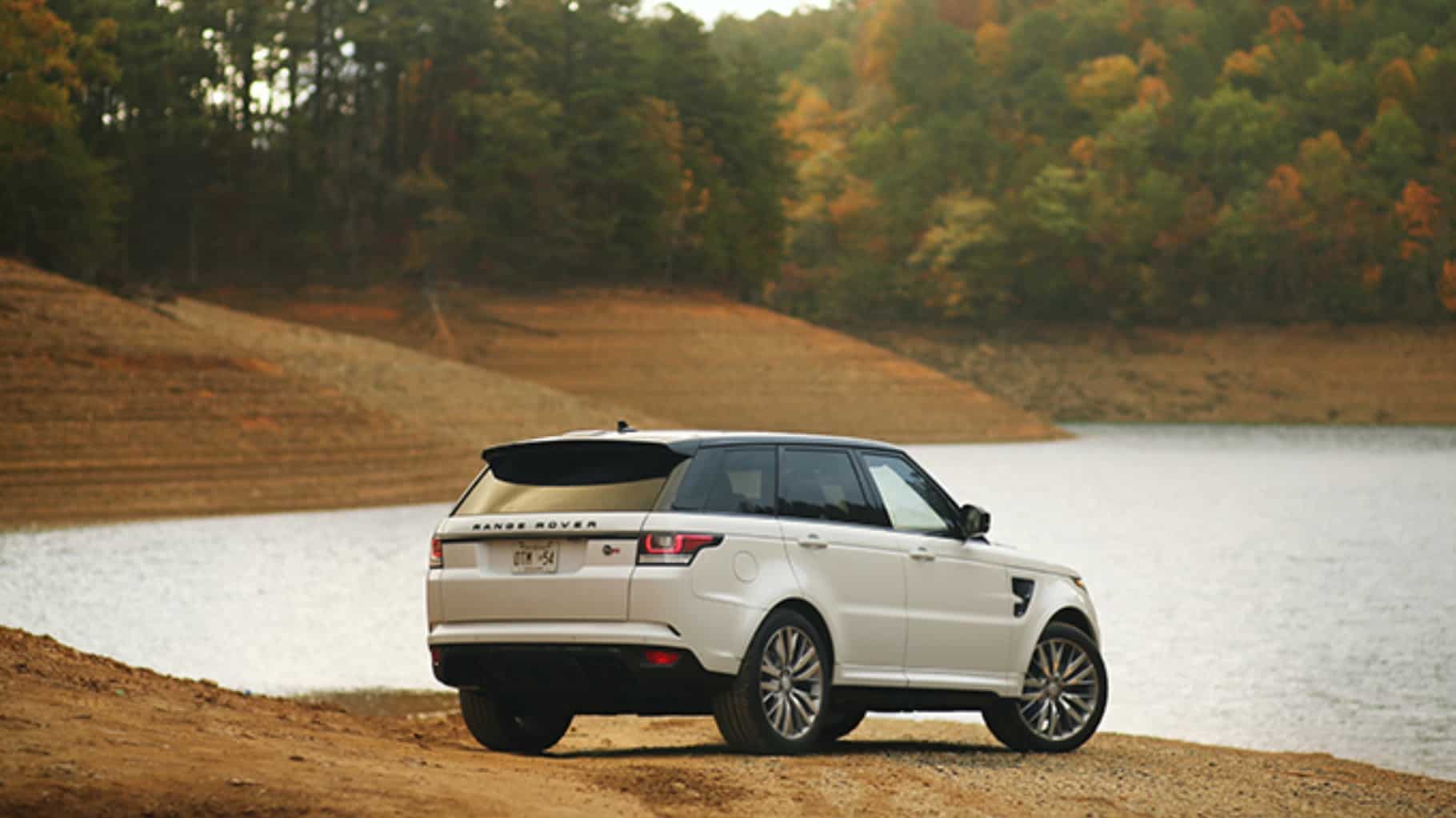  Range Rover Sport parked by a lake during fall rear side view.