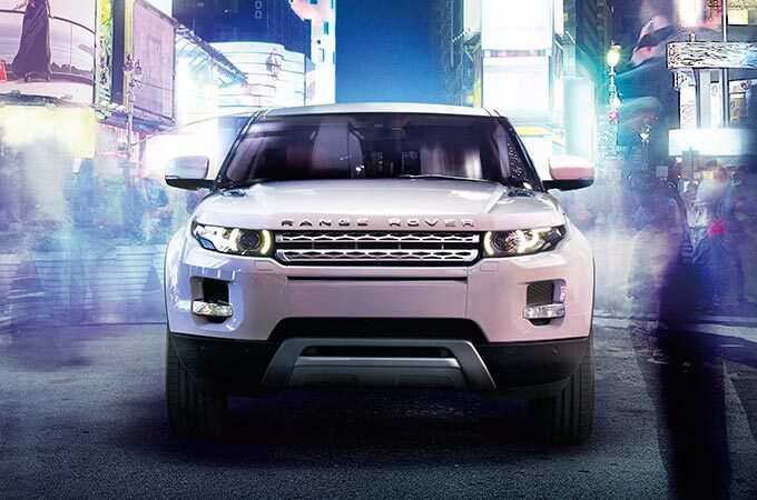 Range Rover Evoque surrounded by city lights front view.