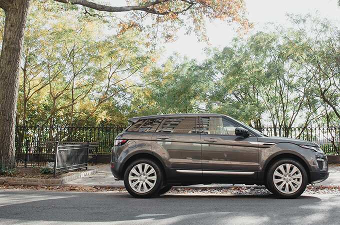 Range Rover Evoque on a city street by a park in New York City.