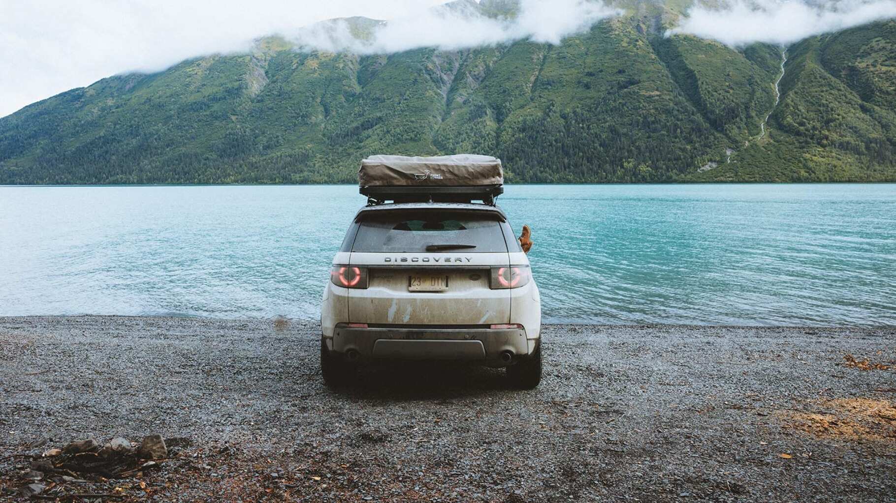 Land Rover Discovery Sport rear view against a beautiful landscape of the Alaskan coast. 