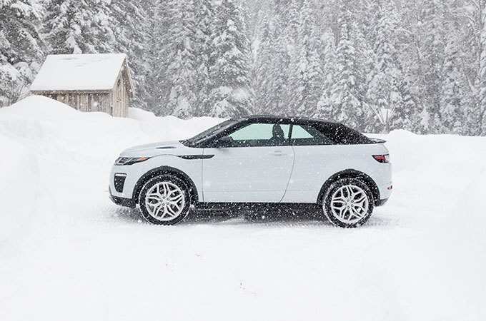 Range Rover Evoque Convertible during snowfall side view.