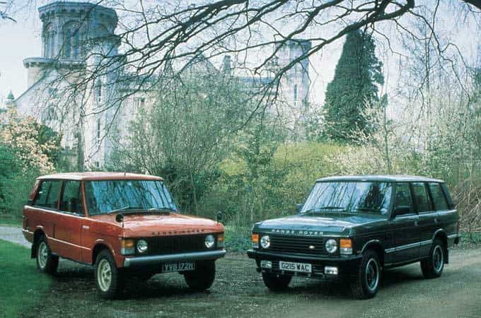 Range Rover Classic vehicles on display in front of a castle.