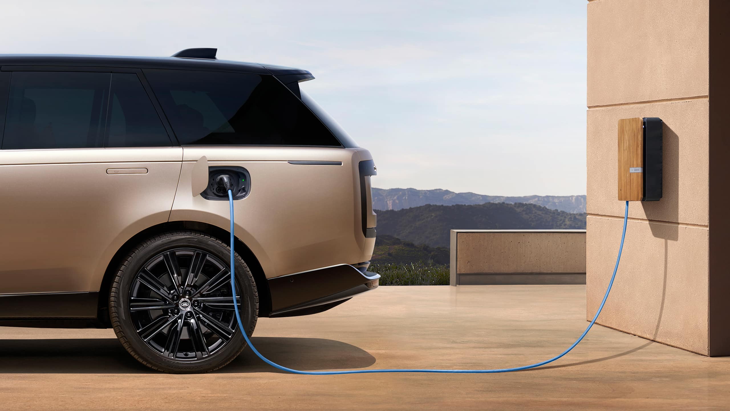 A Range Rover is plugged in to a home charger